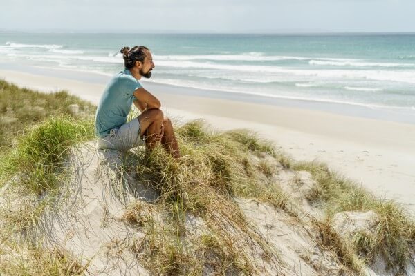 Homme dans les dunes regardant la mer