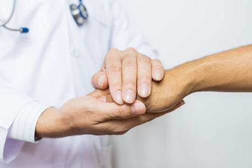 détail des mains d'un patient et de son médecin