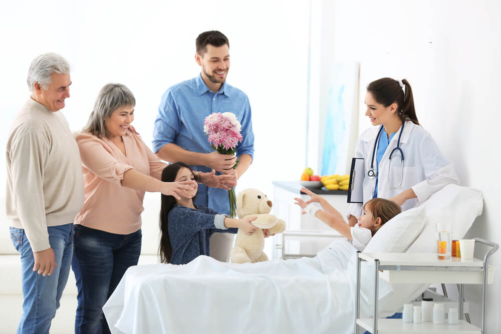 Famille autour d'une petite fille patiente de l'hopital moment heureux